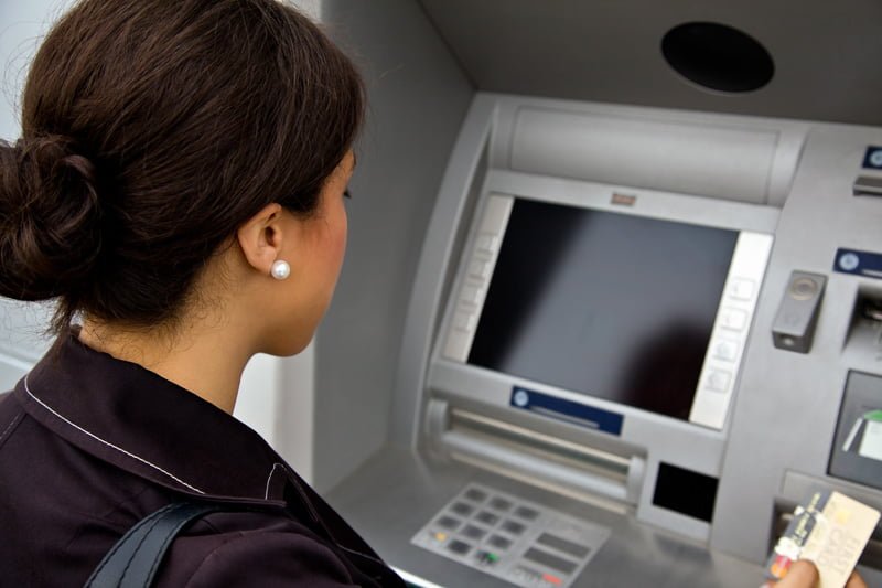 WOMAN USES AN ATM MACHINE. PHOTO: AXIS COMMUNICATIONS